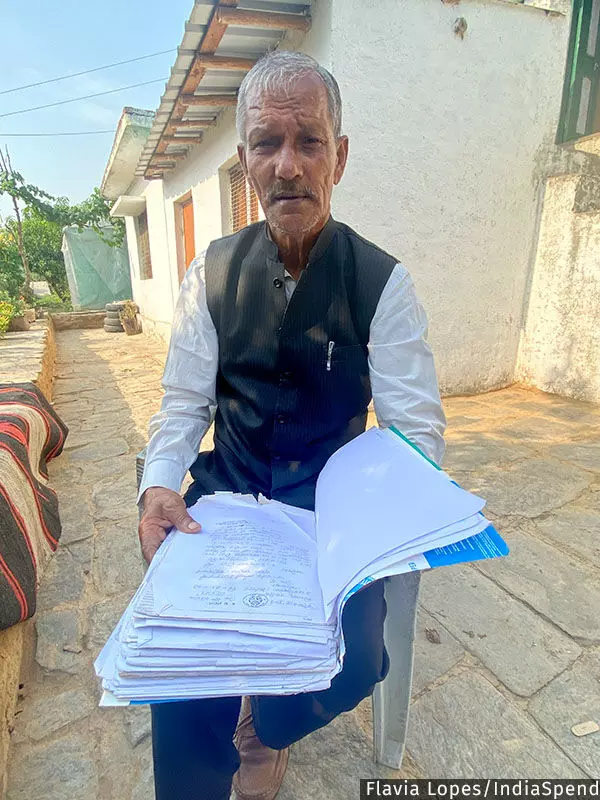 घरगांव गांव के 67 वर्षीय गोविंद सिंह बिष्ट अपनी फाइल के साथ जिसमें वन पंचायतों के बारे में 1990 के दशक के शिकायत पत्र और दस्तावेज शामिल हैं।
